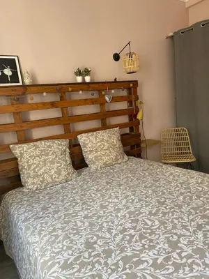 a bedroom with a large bed with a wooden headboard at appartement cosy in Nice