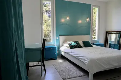 a bedroom with a bed with blue walls and windows at Les Lucioles - Vue mer, AC, Wi-Fi, 4 pers in Villefranche-sur-Mer