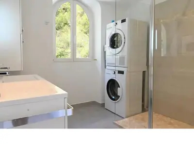 a white kitchen with a washer and dryer in it at Les Lucioles - Vue mer, AC, Wi-Fi, 4 pers in Villefranche-sur-Mer