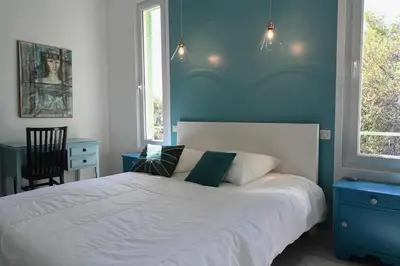 a bedroom with a white bed and a blue wall at Les Lucioles - Vue mer, AC, Wi-Fi, 4 pers in Villefranche-sur-Mer