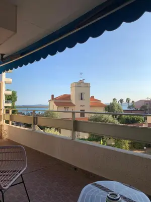 a balcony with a table and a view of the ocean at Cozy Beachside Apartment in Cros de Cagnes - Luna in Cagnes-sur-Mer