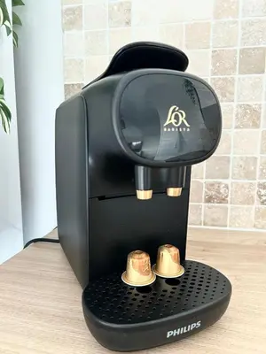 a black coffee maker with two golden cups at Cozy Beachside Apartment in Cros de Cagnes - Luna in Cagnes-sur-Mer