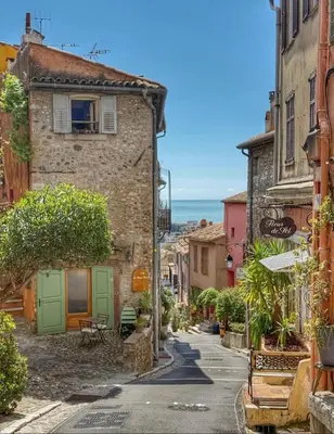 an alley in an old town with the ocean at Cozy Beachside Apartment in Cros de Cagnes - Luna in Cagnes-sur-Mer