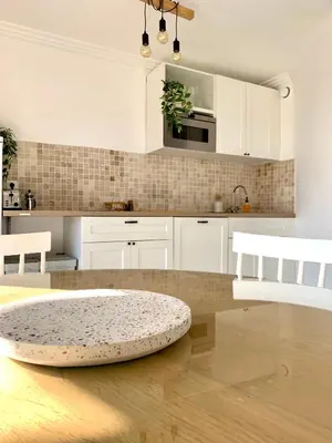 a kitchen with white cabinets and a wooden floor at Cozy Beachside Apartment in Cros de Cagnes - Luna in Cagnes-sur-Mer
