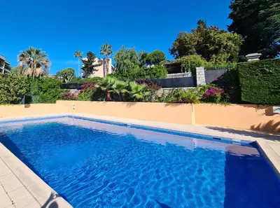 a swimming pool with blue water in front of a fence at Studio grande terrasse à 5 min de la mer in Nice