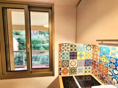 a kitchen with tiles on the wall and a window at Studio grande terrasse à 5 min de la mer in Nice