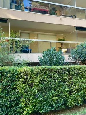 a green hedge in front of a building at Studio grande terrasse à 5 min de la mer in Nice