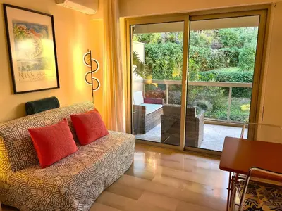 a living room with a couch and a sliding glass door at Studio grande terrasse à 5 min de la mer in Nice