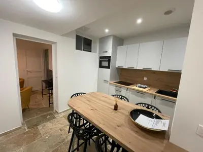 a kitchen with a wooden table and chairs at Vieux-Nice 3 pièces confortable et calme in Nice