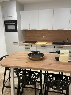 a kitchen with a wooden table with two chairs at Vieux-Nice 3 pièces confortable et calme in Nice
