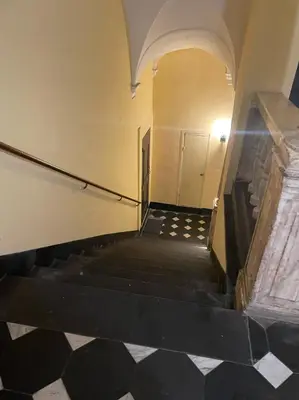 an empty hallway with stairs and a white door at Triplex Toit-Terrasse Authentique Vieux-Nice & Mer in Nice