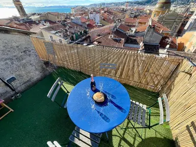 a bottle of wine on a blue table on top of a building at Triplex Toit-Terrasse Authentique Vieux-Nice & Mer in Nice