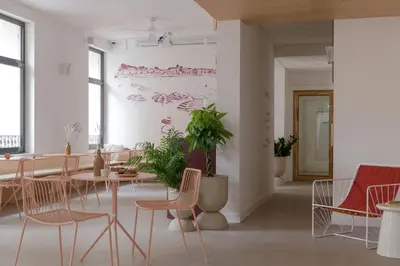 a room with tables and chairs with umbrellas on the wall at SLO Hostel Nice in Nice