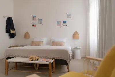 a bedroom with a bed with a table and pictures on the wall at SLO Hostel Nice in Nice