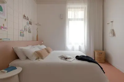 a white bed in a room with a window at SLO Hostel Nice in Nice