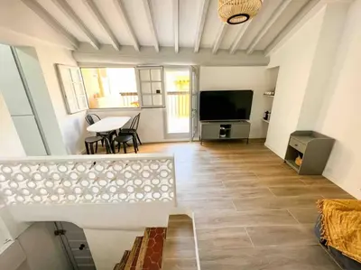 a living room with a table and a tv at Beautiful Top Floor & Terrasse (Beach 1' walk) in Nice