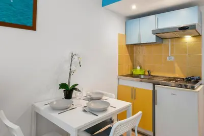 a kitchen with a white table with bowls on it at Studio Azur FSH in Nice