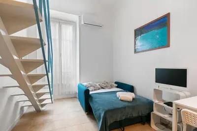a living room with a staircase and a couch and a television at Studio Azur FSH in Nice