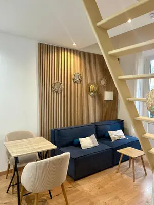 a living room with a blue couch and a table at Le ruisseau in Nice