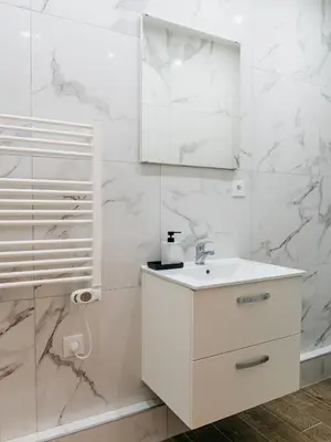 a white bathroom with a sink and a mirror at Studio Nicehome Massena in Nice