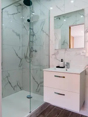 a bathroom with a shower with a sink and a mirror at Studio Nicehome Massena in Nice