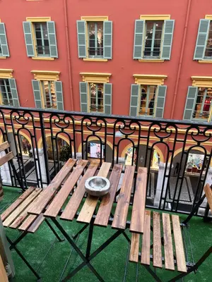 a wooden bench sitting on top of a balcony at Studio Nicehome Massena in Nice