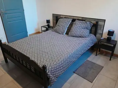 a bed in a bedroom with two night stands and two tables at Appartement spacieux &très calme. Spacious & very quiet apartment. in Carros