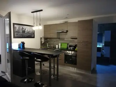 a kitchen with a table and two bar stools at Appartement spacieux &très calme. Spacious & very quiet apartment. in Carros