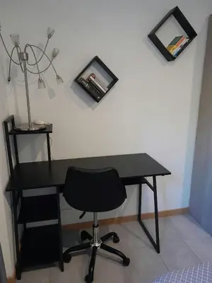 a black desk with a chair and a lamp at Appartement spacieux &très calme. Spacious & very quiet apartment. in Carros
