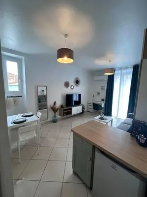 a kitchen and living room with a table and chairs at Studio dans villa proche mer in Nice