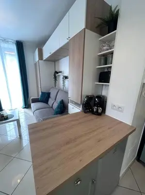 a kitchen with a wooden counter top in a living room at Studio dans villa proche mer in Nice