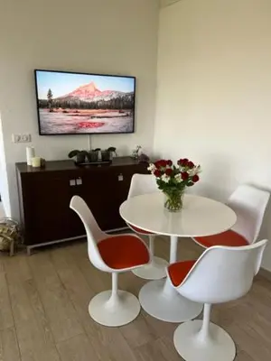 a room with a table and chairs and a tv at Superbe appartement grande corniche vue sur mer Nice à 4 min du centre ville in Nice