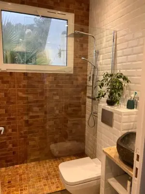 a bathroom with a shower and a toilet and a window at Superbe appartement grande corniche vue sur mer Nice à 4 min du centre ville in Nice