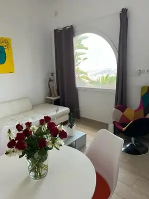 a living room with a vase of flowers on a table at Superbe appartement grande corniche vue sur mer Nice à 4 min du centre ville in Nice