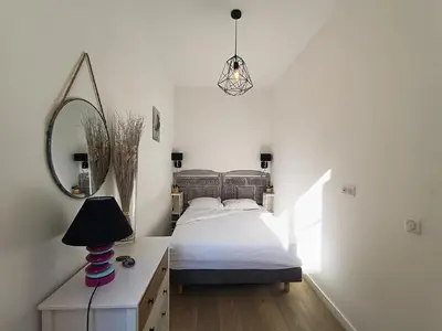 a bedroom with a bed and a mirror and a lamp at Superbe 2 pièces Carré d’or avec grande Terrasse in Nice