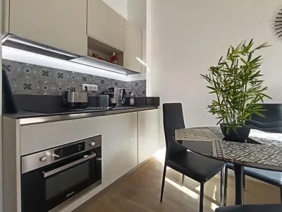 a kitchen with a table and a stove top oven at Superbe 2 pièces Carré d’or avec grande Terrasse in Nice