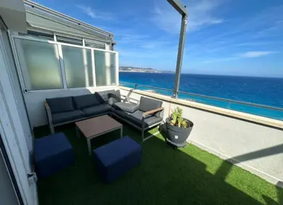 a balcony with a table and chairs and the ocean at Magnifique vue mer la Californie in Nice