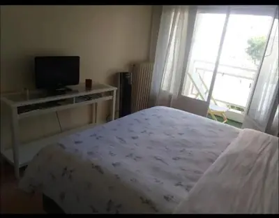 a bedroom with a bed and a tv and a window at En plein coeur de Nice in Nice