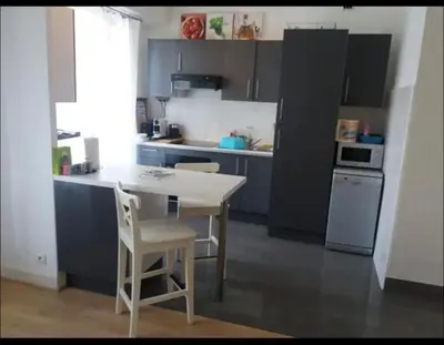 a kitchen with a table and chairs and a refrigerator at En plein coeur de Nice in Nice