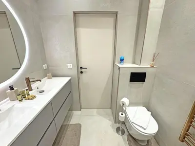a white bathroom with a toilet and a sink at Sea Front Condo Promenade in Nice