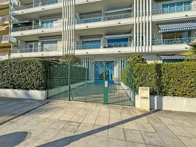 a green gate in front of a building at Sea Front Condo Promenade in Nice