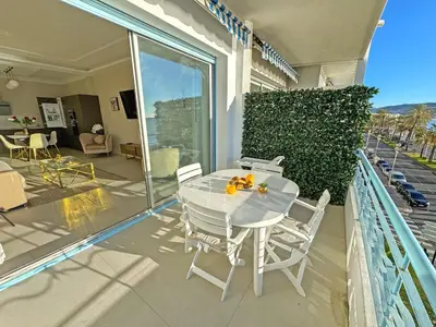a white table and chairs on the balcony of a house at Sea Front Condo Promenade in Nice