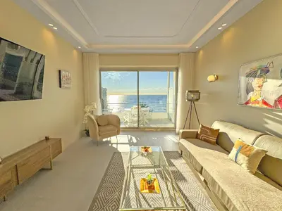 a living room with a couch and a glass table at Sea Front Condo Promenade in Nice