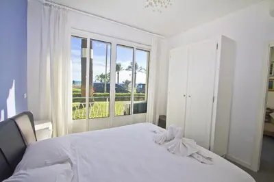 a bedroom with a white bed and a large window at Garden Floor Condo with Promenade Sea View in Nice