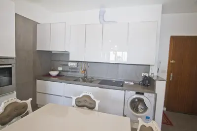 a kitchen with a table and a washing machine at Garden Floor Condo with Promenade Sea View in Nice