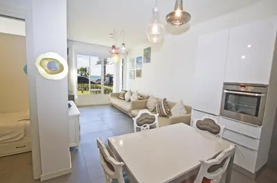a kitchen and living room with a table and a couch at Garden Floor Condo with Promenade Sea View in Nice