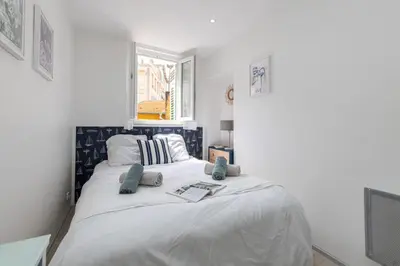 a bedroom with a large white bed with blue pillows at MY CASA - MALONAT - Cosy Apart in Old Town w AC in Nice