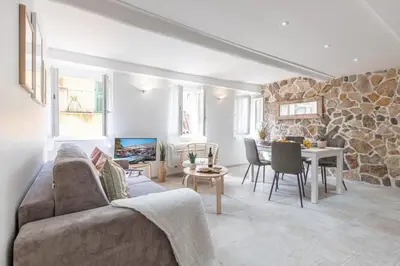 a living room with a couch and a stone wall at MY CASA - MALONAT - Cosy Apart in Old Town w AC in Nice