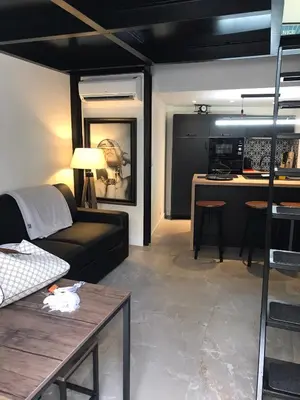 a living room with a couch and a kitchen at Une atypique et merveilleuse Petite maison en plein cœur de Nice, à proximité de la mer et des plages in Nice