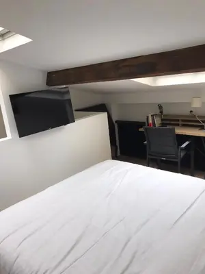 a bedroom with a white bed and a desk at Une atypique et merveilleuse Petite maison en plein cœur de Nice, à proximité de la mer et des plages in Nice